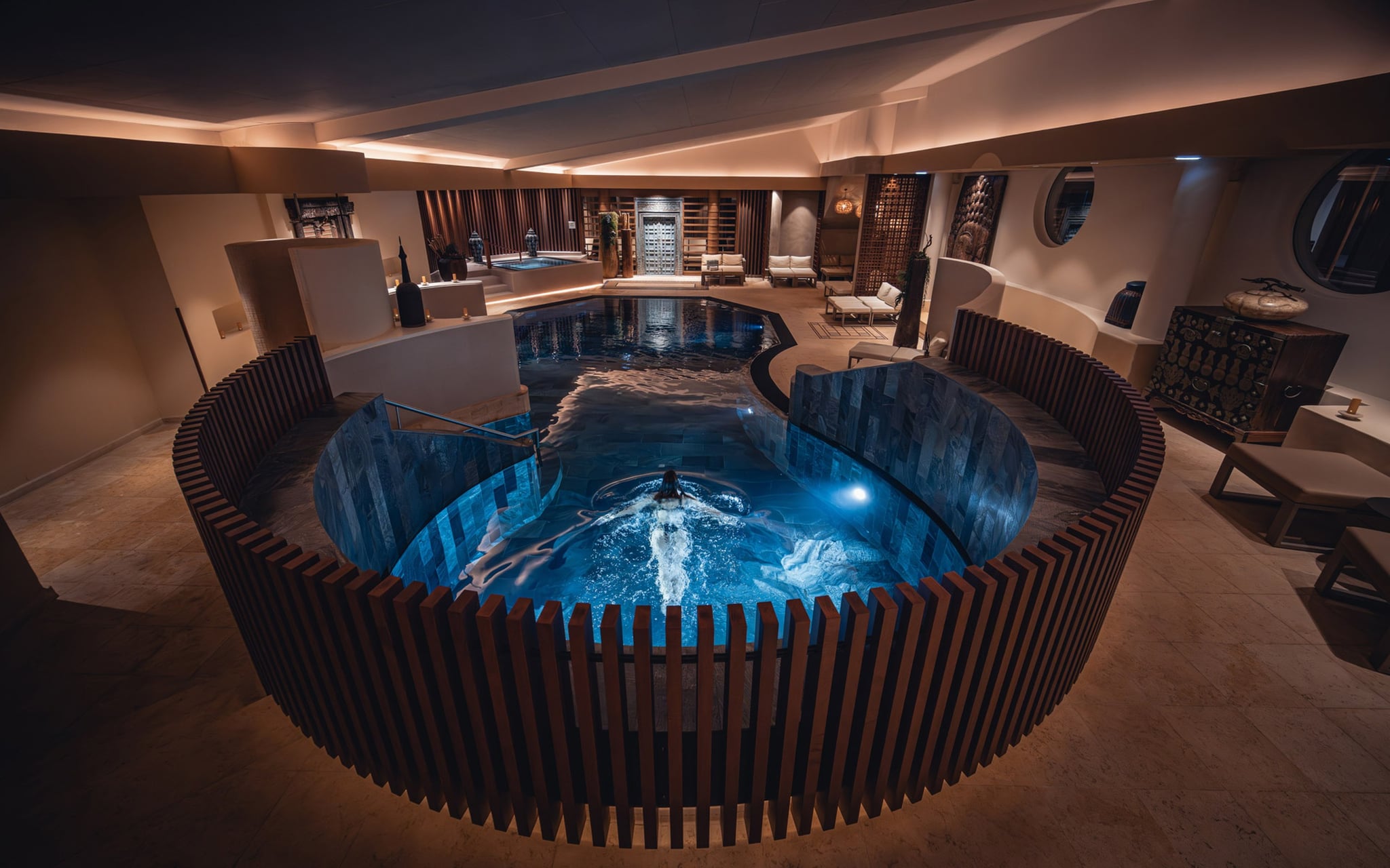 Piscine intérieure éclairée, ambiance chaleureuse.